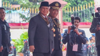 Menteri Pertahanan dan Presiden Terpilih Prabowo Subianto (kiri) didampingi Kapolri Jenderal Pol Listyo Sigit Prabowo (kanan) menyapa awak media di Mabes Polri, Jakarta, Kamis (20/6/2024). [Suara.com/Alfian Winanto]