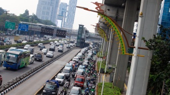 Sejumlah kendaraan melintas di kawasan Gatot Subroto, Jakarta, Senin (24/6/2024). [Suara.com/Alfian Winanto]