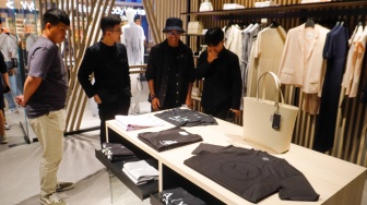 Pengunjung memilih pakaian saat pembukaan Armani Exchange Store Indonesia di Grand Indonesia, Jakarta, Rabu (26/6/2024). [Suara.com/Alfian Winanto]