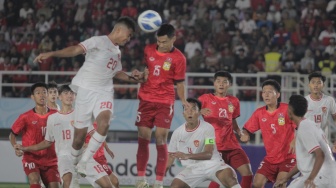 Striker Timnas Indonesia U-16, Josh Holong Junior (20) berduel udara dengan pemain Laos dalam pertandingan ketiga Grup A Piala AFF U-16 2024 di Stadion Manahan, Solo, Kamis (27/6/2024). [Suara.com / Ronald Seger Prabowo]