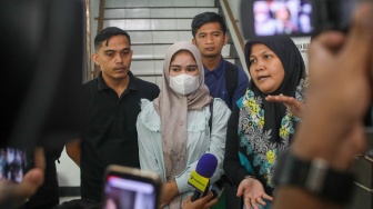 Ibunda Afif Maulana, Anggun Andriani (tengah)  menunjukkan foto anaknya saat usai melakukan audiensi di kantor Komnas HAM, Jakarta, Senin (1/7/2024). [Suara.com/Alfian Winanto]