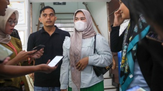 Ibunda Afif Maulana, Anggun Andriani (tengah)  menunjukkan foto anaknya saat usai melakukan audiensi di kantor Komnas HAM, Jakarta, Senin (1/7/2024). [Suara.com/Alfian Winanto]