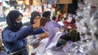 Warga memilih seragam sekolah di Toko Seragam di Pasar Jatinegara, Jakarta, Selasa (2/7/2024). [Suara.com/Alfian Winanto]