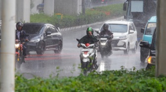 Pengendara motor melintas saat hujan lebat di Jalan Gatot Subroto, Jakarta, Selasa (2/7/2023). [Suara.com/Alfian Winanto]