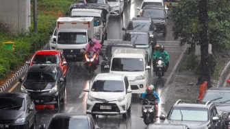 Pengendara motor melintas saat hujan lebat di Jalan Gatot Subroto, Jakarta, Selasa (2/7/2023). [Suara.com/Alfian Winanto]