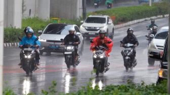 Pengendara motor melintas saat hujan lebat di Jalan Gatot Subroto, Jakarta, Selasa (2/7/2023). [Suara.com/Alfian Winanto]