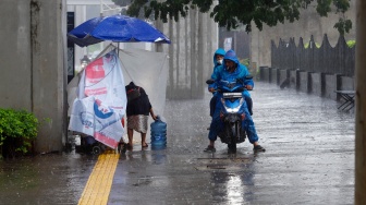 Ojek online menjemput penumpang saat hujan lebat di Jalan Gatot Subroto, Jakarta, Selasa (2/7/2023). [Suara.com/Alfian Winanto]