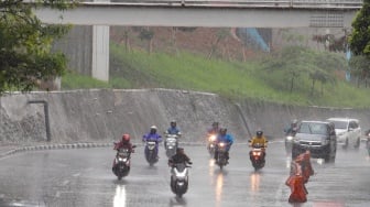 Pengendara motor melintas saat hujan lebat di Jalan Gatot Subroto, Jakarta, Selasa (2/7/2023). [Suara.com/Alfian Winanto]