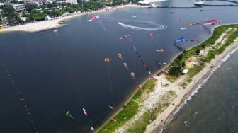 Gambar udara peserta menerbangkan layang-layang saat mengikuti Festival Layang-layang Internasional 2024 di Pantai Lagoon, Taman Impian Jaya Ancol, Jakarta, Kamis (4/7/2024). [Suara.com/Alfian Winanto]