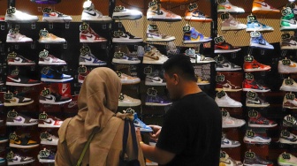 Pengunjung melihat produk sepatu dalam pameran Jakarta Sneaker Day (JSD) 2024 di Jakarta Convention Center (JCC), Senayan, Jakarta, Jumat (5/7/2024). [Suara.com/Alfian Winanto]