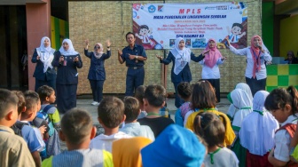 Sejumlah guru menyambut siswa saat menjalani Masa Pengenalan Lingkungan Sekolah (MPLS) di Sekolah Dasar Negeri (SDN) 01 & 03 Kramat, Jakarta, Senin (8/7/2024). [Suara.com/Alfian Winanto]