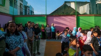 Sejumlah siswa ditemani orang tuanya saat menjalani Masa Pengenalan Lingkungan Sekolah (MPLS) di Sekolah Dasar Negeri (SDN) 01 & 03 Kramat, Jakarta, Senin (8/7/2024). [Suara.com/Alfian Winanto]