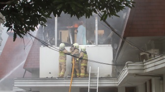 Petugas Pemadam Kemabakaran berusaha memadamkan api yang membakar rumah mewah di Kawasan Menteng, Jakarta, Selasa (9/7/2024). [Suara.com/Alfian Winanto]