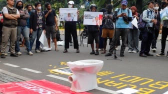 Massa membawa poster saat menggelar aksi di depan gedung Kementerian Komunikasi dan Informatika (Kemenkominfo) di Jakarta, Rabu (10/7/2024). [Suara.com/Alfian Winanto]