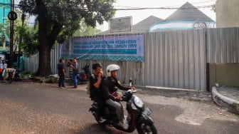 Warga melintas di depan Kantor Perkumpulan Keluarga Berencana Indonesia {PKBI) yang sudah dikosongkan dan ditutupi seng di Jakarta, Kamis (11/7/2024). [Suara.com/Alfian Winanto]