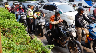 Sejumlah petugas kepolisian memberikan himbauan kepada pengendara yang melanggar peraturan saat Operasi Patuh Jaya 2024 di Jalan Letjen S Parman, Jakarta, Senin (15/07/2024). [Suara.com/Alfian Winanto]