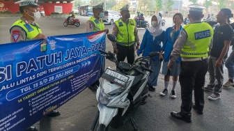 Sejumlah petugas kepolisian memberikan himbauan kepada pengendara yang melanggar peraturan saat Operasi Patuh Jaya 2024 di Jalan Letjen S Parman, Jakarta, Senin (15/07/2024). [Suara.com/Alfian Winanto]