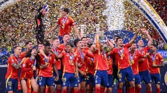 Penyerang Spanyol Alvaro Morata (tengah) berselebrasi mengangkat trofi bersama para pemain Spanyol setelah memenangkan pertandingan sepak bola Final Euro 2024 antara Spanyol dan Inggris di Olympiastadion, Berlin, Jerman, Minggu (14/7/2024). [Kirill KUDRYAVTSEV / AFP]