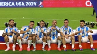 (Kiri-Kanan) Bek Argentina Nicolas Otamendi, penyerang Argentina Lautaro Martinez, penyerang Argentina Angel Di Maria, penyerang Argentina  Leandro Paredes, gelandang Argentina Giovani Lo Celso dan gelandang Argentina Marcos Acuna merayakan dengan medali mereka sepak bola final Copa America 2024 antara Argentina dan Kolombia di Stadion Hard Rock, di Miami, Florida, Minggu (14/7/2024). [JUAN MABROMATA / AFP] 