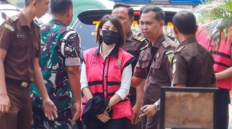 Tersangka kasus dugaan korupsi di PT Timah Helena Lim (tengah) berjalan memasuki gedung saat pelimpahan tahap dua di Kejaksaan Negeri Jakarta Selatan, Jakarta, Senin (22/7/2024). [Suara.com/Alfian Winanto]