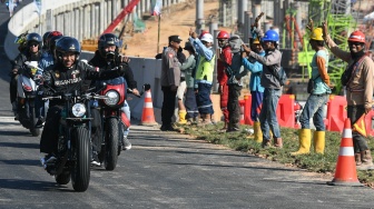 Presiden Joko Widodo (depan) bersama sejumlah influencer media sosial menyapa pekerja saat mengendarai motor melewati Jalan Tol IKN di Balikpapan, Kalimantan Timur, Minggu (28/7/2024). [ANTARA FOTO/Hafidz Mubarak A/Spt]