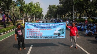 Kelompok sopir Mikrotrans atau angkot Jaklingko dan Mikrolet Jakarta melakukan aksi demonstrasi di depan Balai Kota DKI Jakarta, Selasa (30/7/2024). [Suara.com/Alfian Winanto]