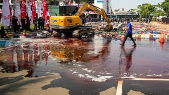 Petugas melakukan pemusnahan minuman keras ilegal hasil penindakan di Kantor Pusat Bea Cukai, Jakarta, Rabu (31/7/2024). [Suara.com/Alfian Winanto]