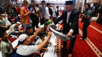 Warga berdonasi untuk Palestina usai melaksanakan salat gaib di Masjid Istiqlal, Jakarta, Jumat (2/8/2024). [Suara.com/Alfian Winanto]