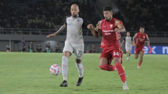 Striker Persija Jakarta, Gustavo Almeida berduel dengan bek Persis Solo, Ricardo Lima dalam laga perebutan tempat ketiga Piala Presiden 2024 di Stadion Manahan, Solo, Sabtu (3/8/2024). [Suara.com/Ronald Seger Prabowo]