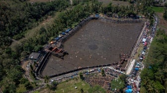 Foto udara ribuan warga menangkap ikan saat kegiatan Kurasan Kolam Tando Harian Sub Unit Pembangkit Listrik Tenaga Air (PLTA) Timo di Desa Tlompakan, Kecamatan Tuntang, Kabupaten Semarang, Jawa Tengah, Senin (5/8/2024). [ANTARA FOTO/Aji Styawan/foc]