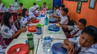 Siswa menyantap makanan saat mengikuti uji coba pelaksanaan program makan bergizi gratis di SDN 4 Tangerang, Kota Tangerang, Banten, Senin (5/8/2024). [ANTARA FOTO/Galih Pradipta/foc]