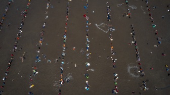 Foto udara sejumlah warga menjaring ikan saat Kurasan Kolam Tando Harian Sub Unit Pembangkit Listrik Tenaga Air (PLTA) Timo di Desa Tlompakan, Kecamatan Tuntang, Kabupaten Semarang, Jawa Tengah, Senin (5/8/2024). [ANTARA FOTO/Aji Styawan/foc]