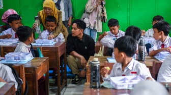 Wakil Presiden terpilih Gibran Rakabuming Raka berbincang dengan siswa saat meninjau uji coba pelaksanaan program makan bergizi gratis di SDN 4 Tangerang, Kota Tangerang, Banten, Senin (5/8/2024). [ANTARA FOTO/Galih Pradipta/foc]
