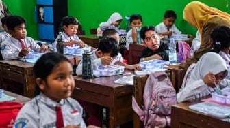 Wakil Presiden terpilih Gibran Rakabuming Raka berbincang dengan siswa saat meninjau uji coba pelaksanaan program makan bergizi gratis di SDN 4 Tangerang, Kota Tangerang, Banten, Senin (5/8/2024). [ANTARA FOTO/Galih Pradipta/foc]