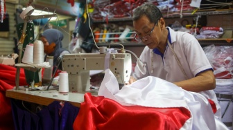 Penjahit menyelesaikan pesanan rempel bendera di Pasar Senen, Jakarta, Rabu (7/8/2024). [Suara.com/Alfian Winanto]