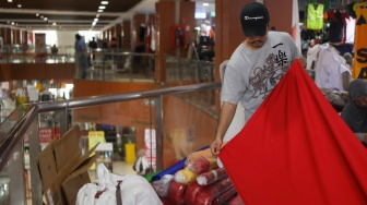 Penjahit menyelesaikan pesanan rempel bendera di Pasar Senen, Jakarta, Rabu (7/8/2024). [Suara.com/Alfian Winanto]