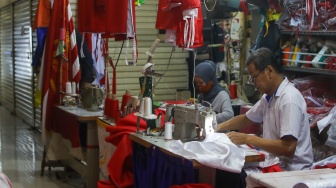 Penjahit menyelesaikan pesanan rempel bendera di Pasar Senen, Jakarta, Rabu (7/8/2024). [Suara.com/Alfian Winanto]