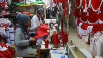 Penjahit menyelesaikan pesanan rempel bendera di Pasar Senen, Jakarta, Rabu (7/8/2024). [Suara.com/Alfian Winanto]