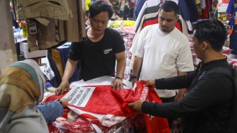 Penjahit menyelesaikan pesanan rempel bendera di Pasar Senen, Jakarta, Rabu (7/8/2024). [Suara.com/Alfian Winanto]