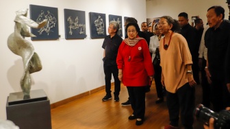 Presiden ke-5 RI Megawati Soekarnoputri (tengah) didampingi pematung Dolorosa Sinaga saat melihat pameran seni patung di Galeri Nasional, Jakarta, Kamis (8/8/20204). [Suara.com/Alfian Winanto] 