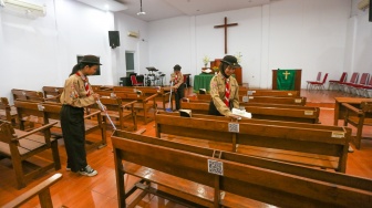 Anggota Pramuka membersihkan ruangan ibadah saat kegiatan bakti sosial pramuka di Gereja Kristen Indonesia, Kebon Bawang, Jakarta Utara, Jumat (9/8/2024). [Suara.com/Alfian Winanto]