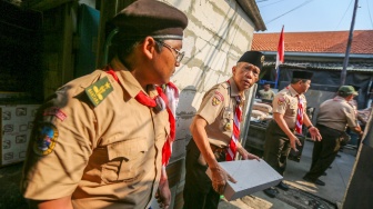 Anggota Kwarnas Pramuka membantu memasukkan bahan bangunan untuk bedah rumah warga saat kegiatan bakti sosial pramuka di Kebon Bawang, Jakarta Utara, Jumat (9/8/2024). [Suara.com/Alfian Winanto]