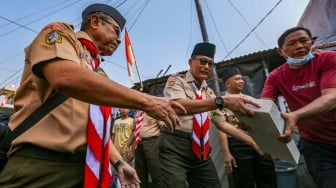 Ketua Kwarnas Gerakan Pramuka Budi Waseso (tengah) membantu memasukkan bahan bangunan untuk bedah rumah warga saat kegiatan bakti sosial pramuka di Kebon Bawang, Jakarta Utara, Jumat (9/8/2024). [Suara.com/Alfian Winanto]