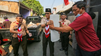 Ketua Kwarnas Gerakan Pramuka Budi Waseso (tengah) membantu memasukkan bahan bangunan untuk bedah rumah warga saat kegiatan bakti sosial pramuka di Kebon Bawang, Jakarta Utara, Jumat (9/8/2024). [Suara.com/Alfian Winanto]