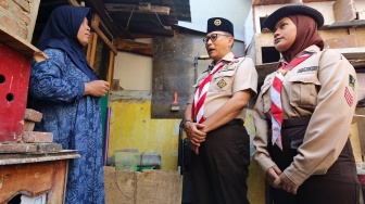 Ketua Kwarnas Gerakan Pramuka Budi Waseso (tengah) membantu memasukkan bahan bangunan untuk bedah rumah warga saat kegiatan bakti sosial pramuka di Kebon Bawang, Jakarta Utara, Jumat (9/8/2024). [Suara.com/Alfian Winanto]