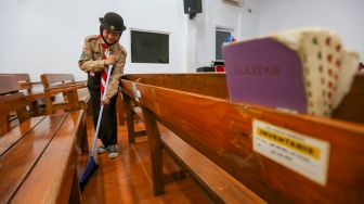 Anggota Pramuka membersihkan ruangan ibadah saat kegiatan bakti sosial pramuka di Gereja Kristen Indonesia, Kebon Bawang, Jakarta Utara, Jumat (9/8/2024). [Suara.com/Alfian Winanto]