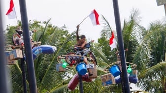 Peserta mengikuti lomba panjat pinang di Pantai Festival, Taman Impian Jaya Ancol, Jakarta, Sabtu (17/8/2024). [Suara.com/Alfian Winanto]