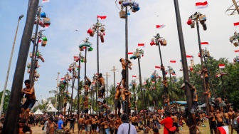 Peserta mengikuti lomba panjat pinang di Pantai Festival, Taman Impian Jaya Ancol, Jakarta, Sabtu (17/8/2024). [Suara.com/Alfian Winanto]