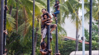 Peserta mengikuti lomba panjat pinang di Pantai Festival, Taman Impian Jaya Ancol, Jakarta, Sabtu (17/8/2024). [Suara.com/Alfian Winanto]