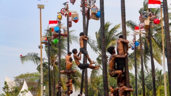 Peserta mengikuti lomba panjat pinang di Pantai Festival, Taman Impian Jaya Ancol, Jakarta, Sabtu (17/8/2024). [Suara.com/Alfian Winanto]